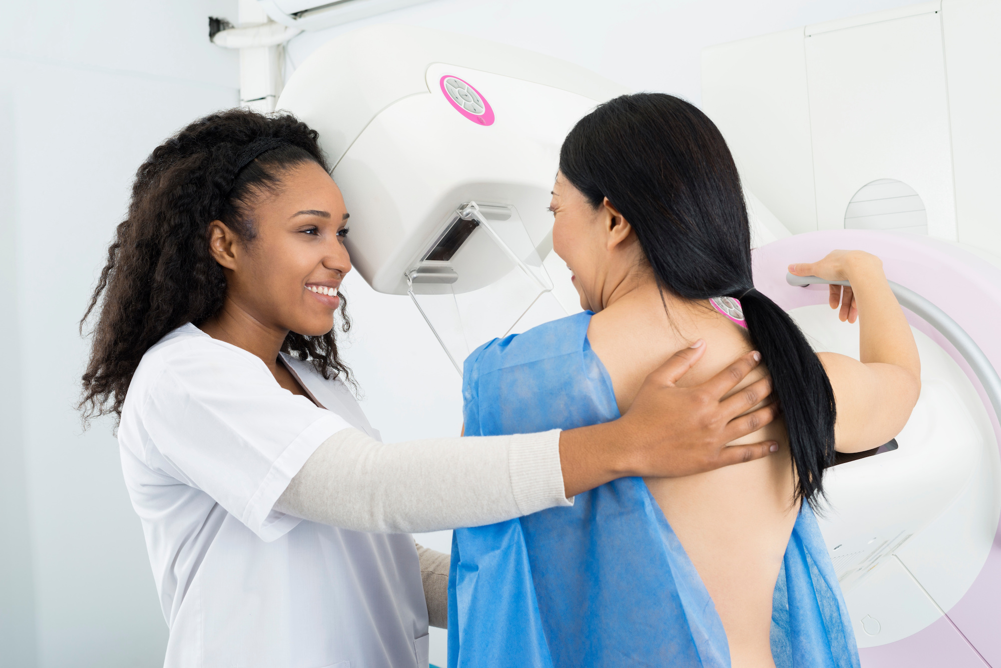 Happy Doctor Assisting Woman Undergoing Mammogram X-ray Test
