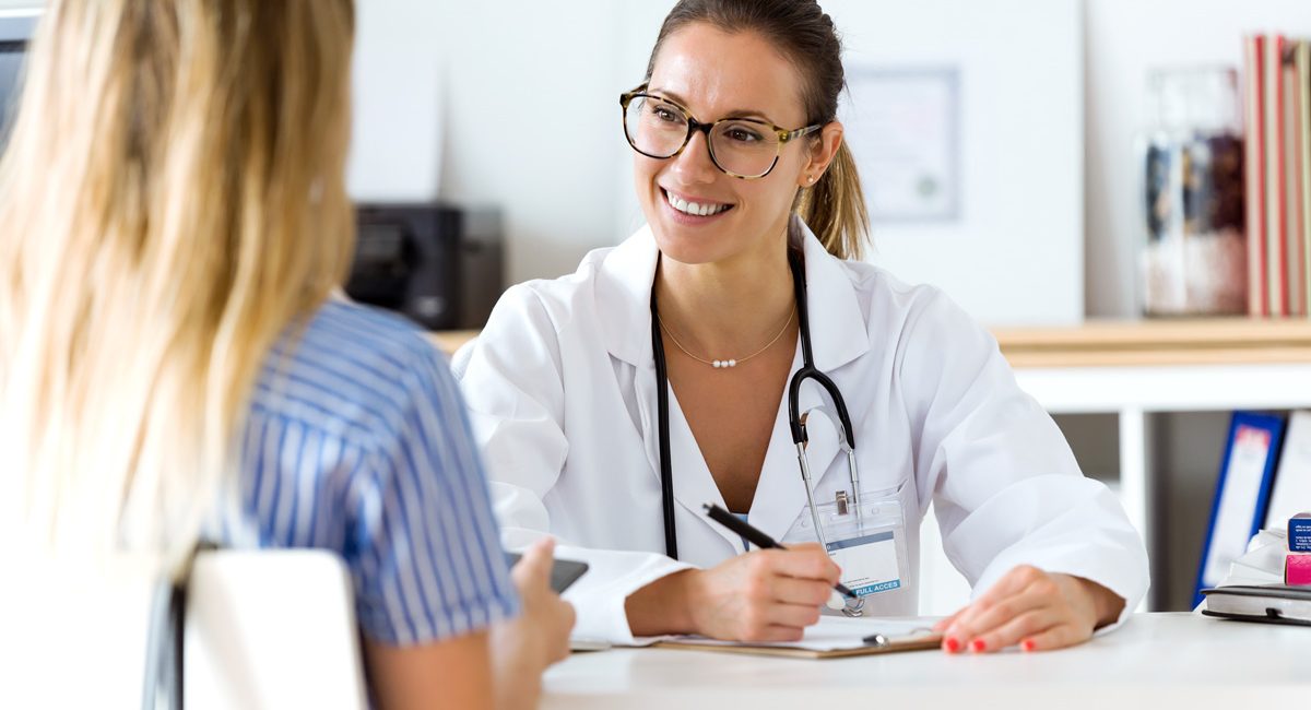 A person speaking to their El Paso primary care physician at a desk.