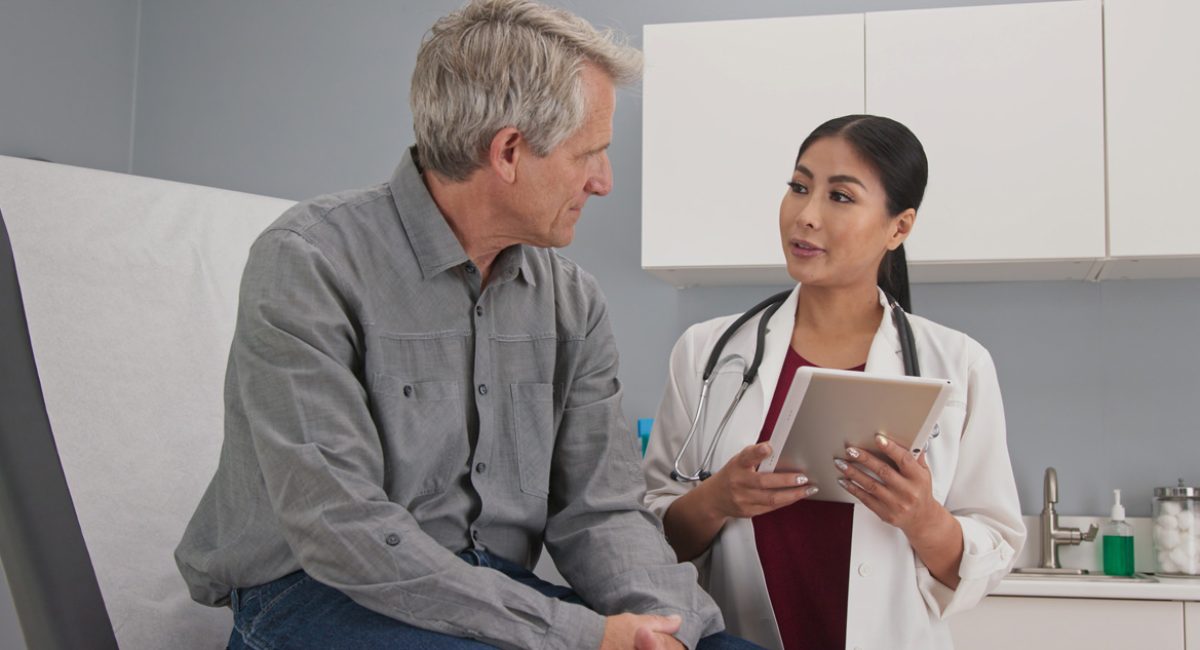 A primary care physician speaking to a patient in an El Paso clinic.